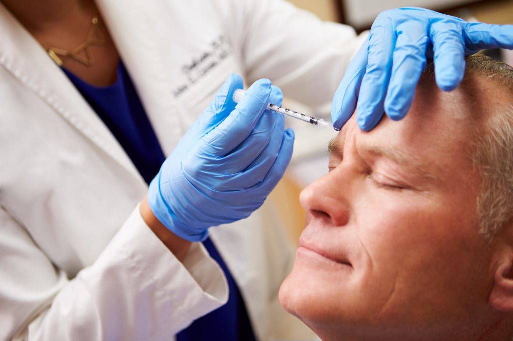 older man receiving botox treatment on face