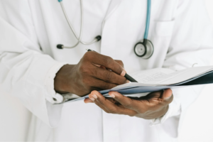 doctor Holding Pen Writing on Paper