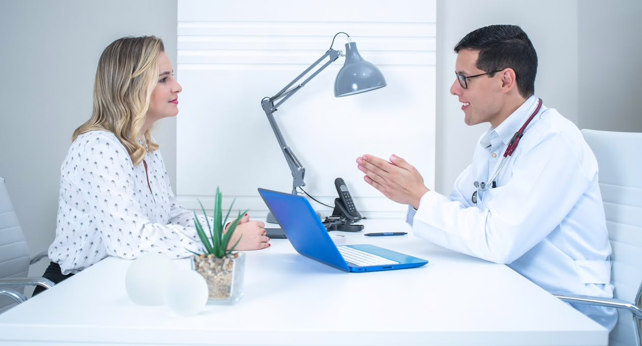 doctor talking with woman in white long sleeve shirt
