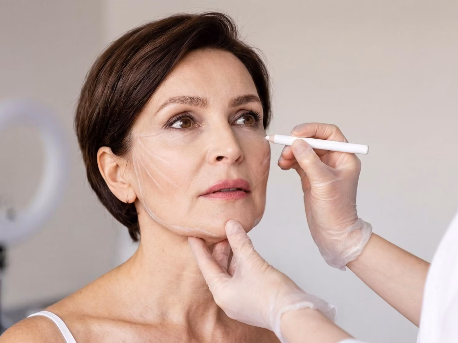 A Beverly Hills facial plastic surgeon reviewing facelift consultation notes with a patient in a clinical setting